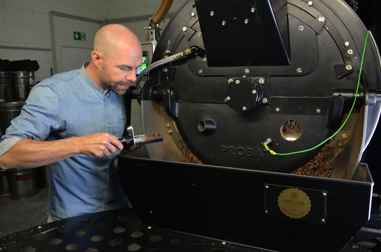 Dominic Müller, Inhaber der Kaffeerösterei Müller, beim Bedienen des Trommelrösters