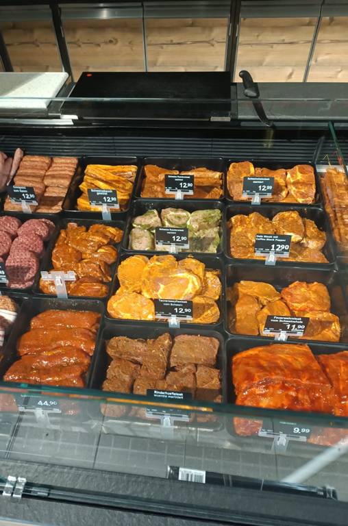 Verschiedenste marinierte Steakvariationen für den Grill in der Auslage der Bedientheke von EDEKA Deckenbach