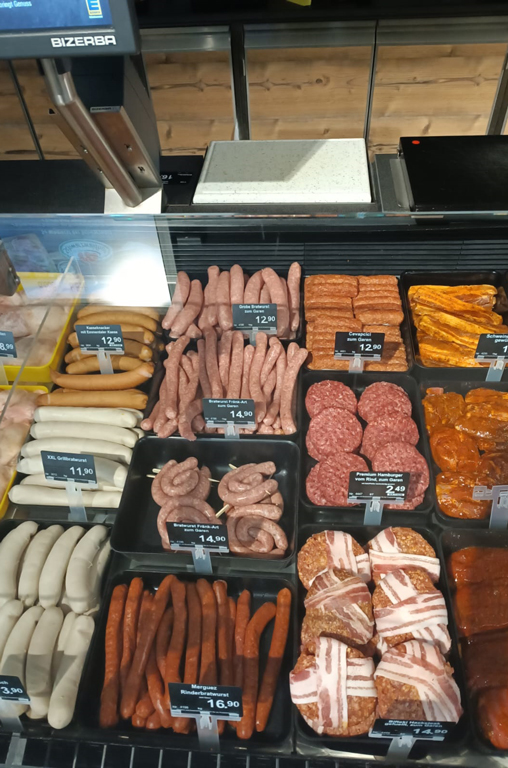 Verschiedenste Bratwurstvariationen für den Grill in der Auslage der Bedientheke von EDEKA Deckenbach