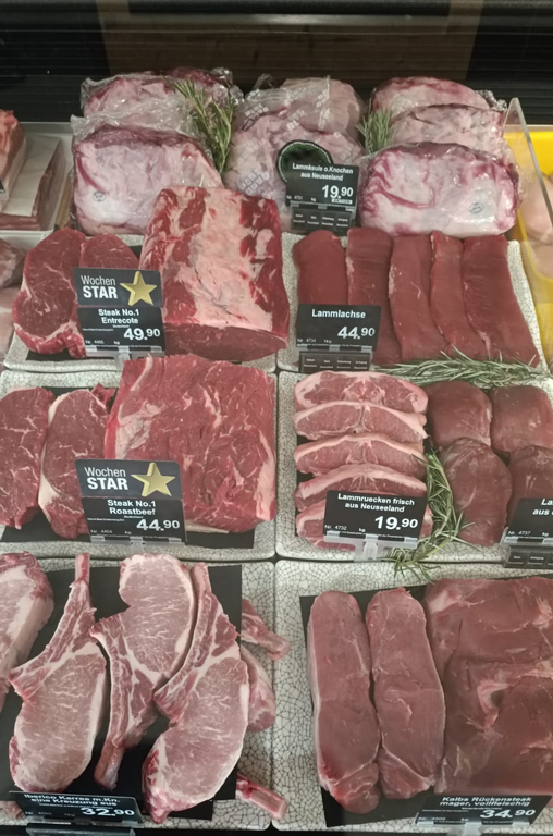 Verschiedenste Fleisch-Teilstücke für den Grill in der Auslage der Bedientheke von EDEKA Deckenbach