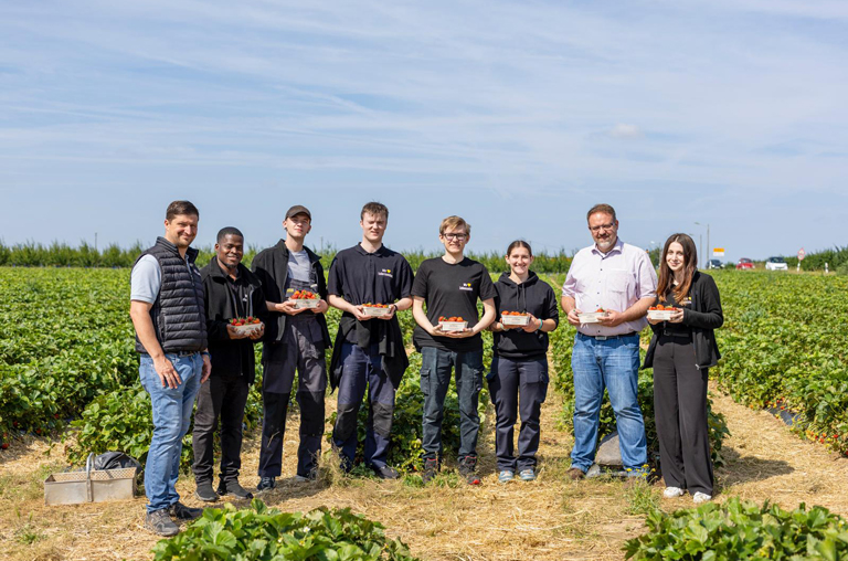 Die EDEKA-Deckenbach-Azubis entdecken den Obsthof Hochhaus und posieren mit Junior-Chef Björn Hochhaus (links) und Ralph Hippe (2. v. r.), Warenbereichsleiter von EDEKA Deckenbach, für ein Erinnerungsfoto