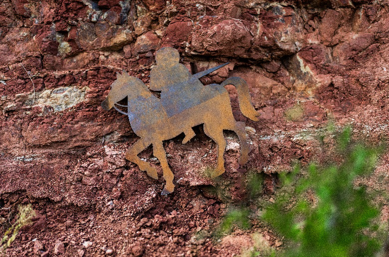 Das Pferd mit Reiter aus dem Logo vom Weingut Martin als Metallemblem auf dem Boden der Weinreben liegend