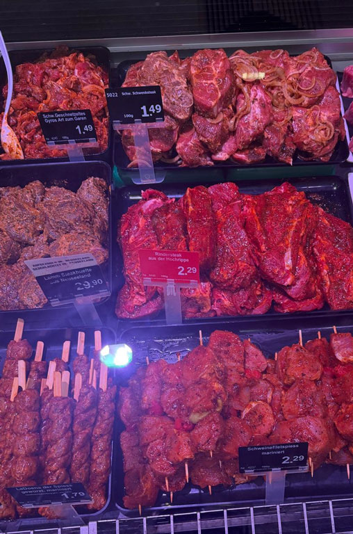 Verschieden marinierte Steaks vom Rind, Schwein und Lamm in der Auslage der Bedientheke von EDEKA Deckenbach