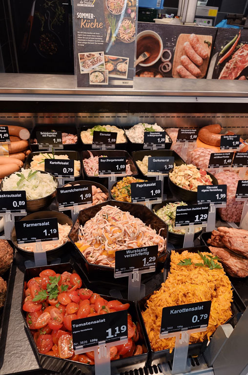 Frisch zubereitete Gemüse- und Fleischsalate in der Auslage der Bedientheke von EDEKA Deckenbach