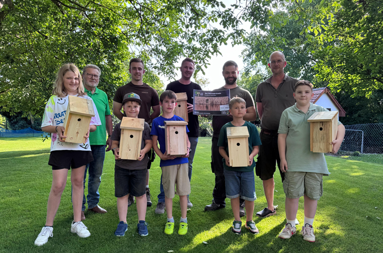 Marktinhaber Klaus Deckenbach (Mitte hinten) beim Gruppenfoto. Im Vordergrund die stolzen Kinder mit ihren selbst gebauten Nistkästen